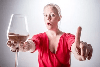 Women holding a glass of wine and pointing accusingly