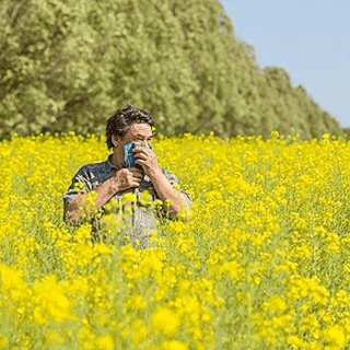 Man struggling with hay fever in a field